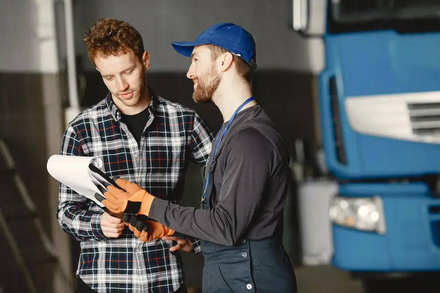 A mechanic going over paperwork with a customer